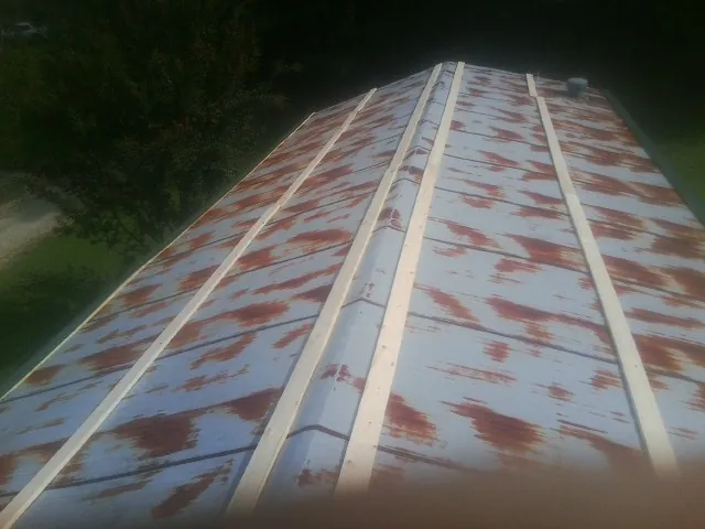 Rusted metal roof panels with new wood purlins before replacement — Storm Damage Roof Repair in Mayo by Roofing Brothers